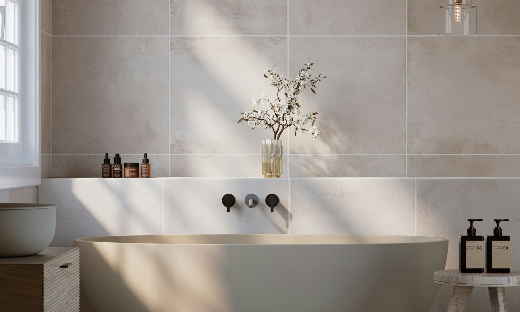 A soft, light spa bathroom with a freestanding tub and blossom branch