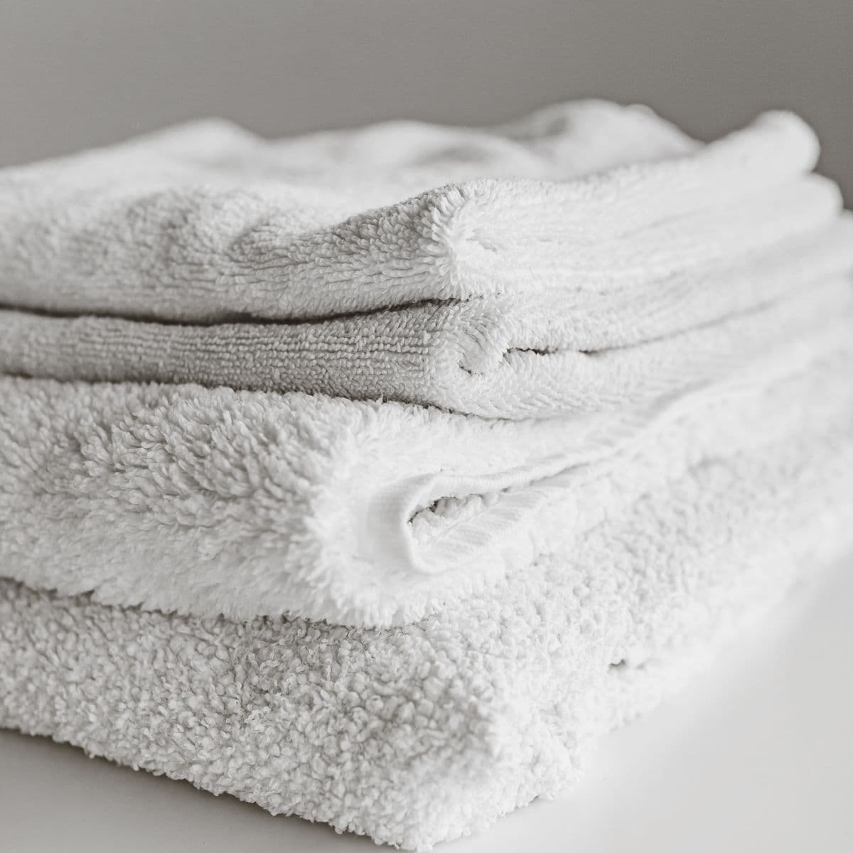 A neatly folded stack of soft white spa towels