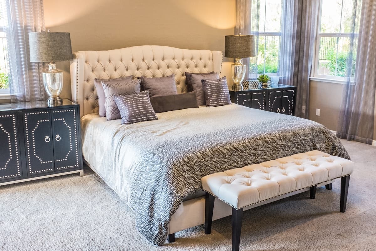 A bed dressed in soft white layered bedding