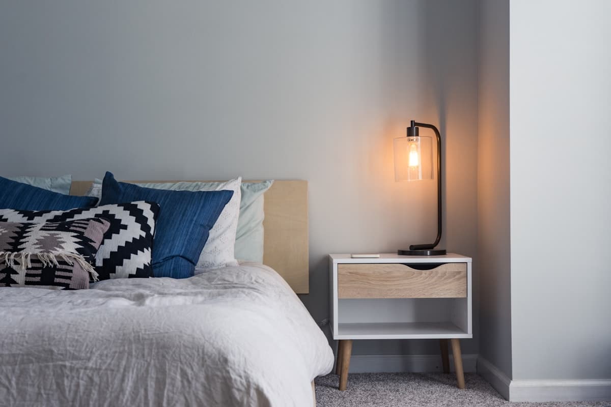 A calm neutral bedroom with light bedding