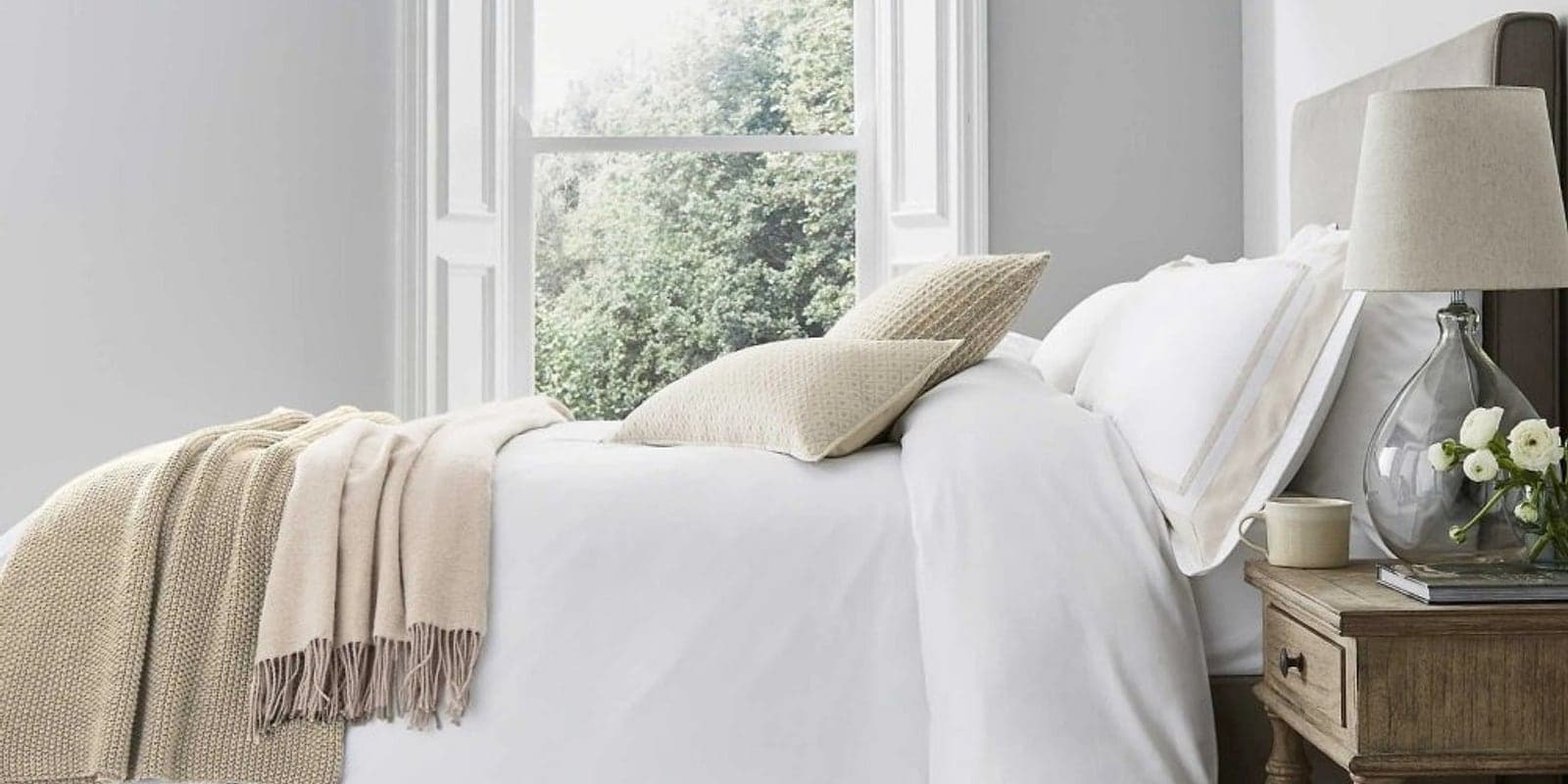 A calm neutral bedroom styled with soft muslin pillows