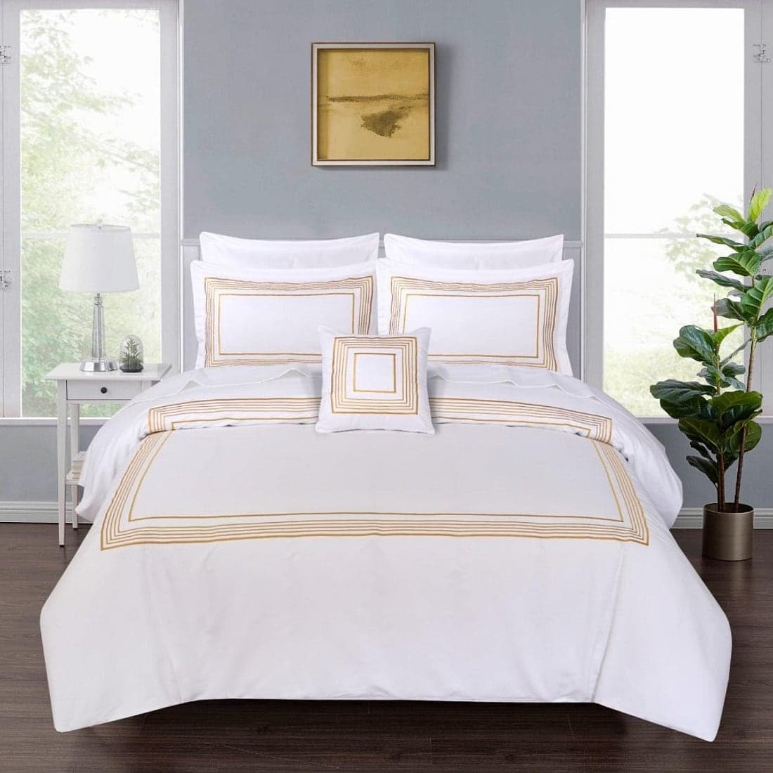 A white iron-frame bed made up with soft cream pillows and linen