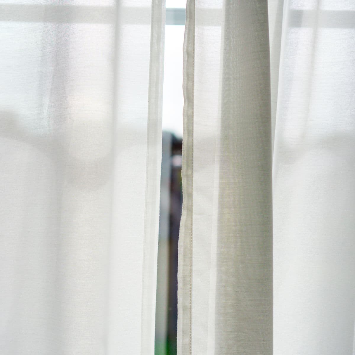 Folds of white sheer voile drapery filtering soft daylight