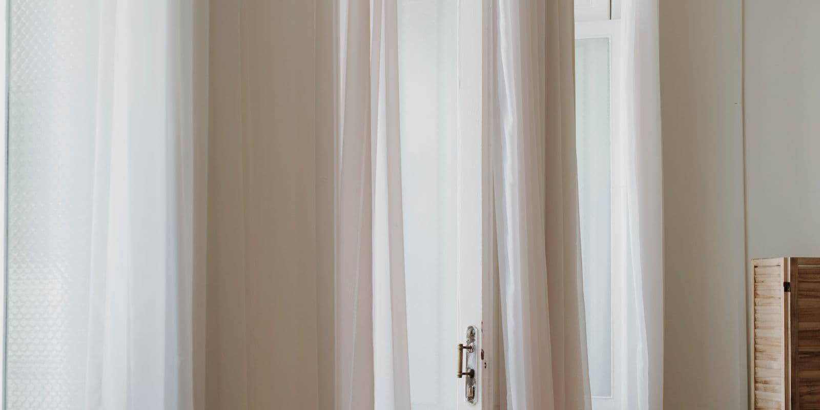 Floor-length white and ivory sheers framing French doors
