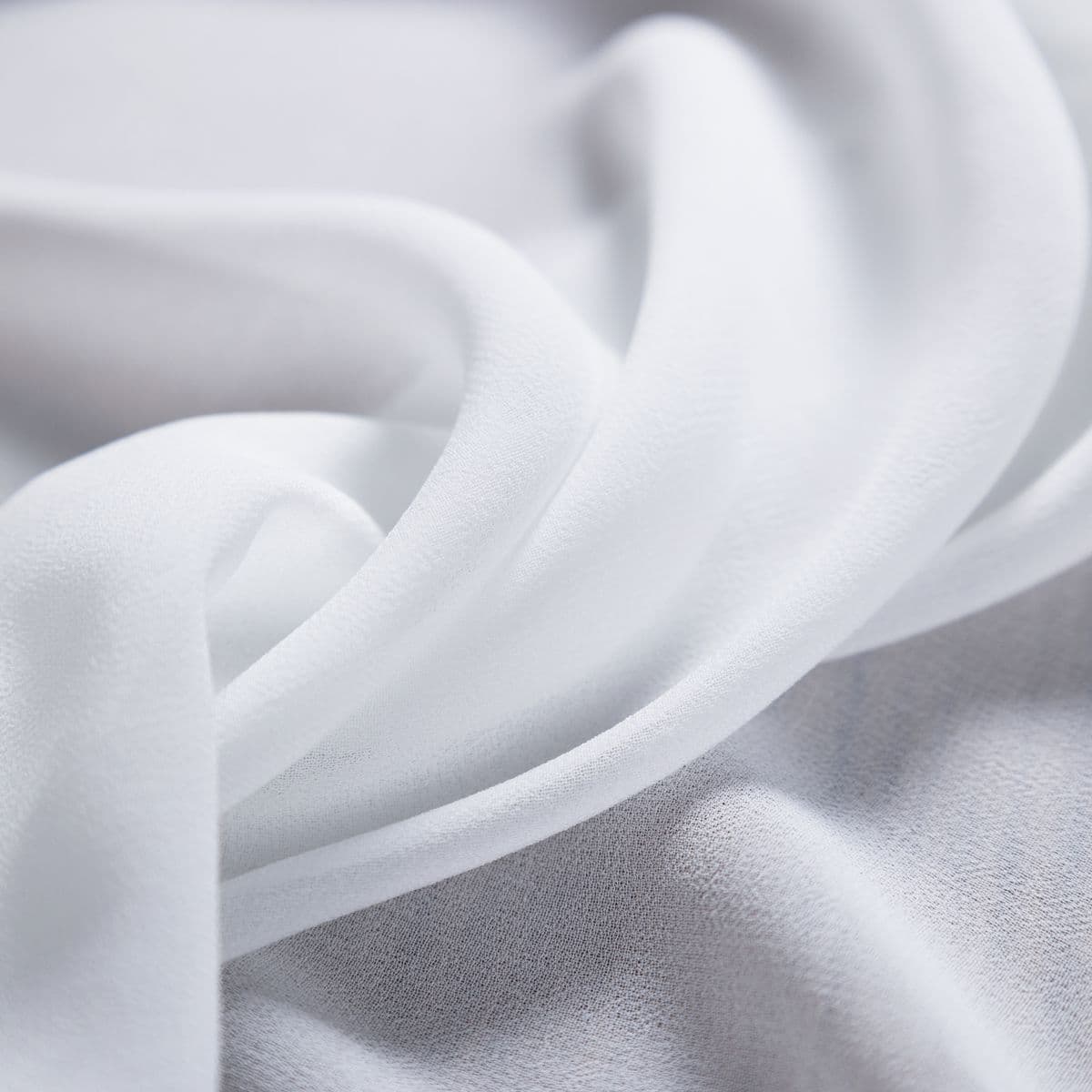 Soft folds of smooth white drapery fabric