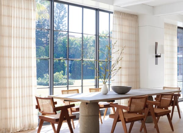 Buff cotton tailored-pleat drapes in a dining room