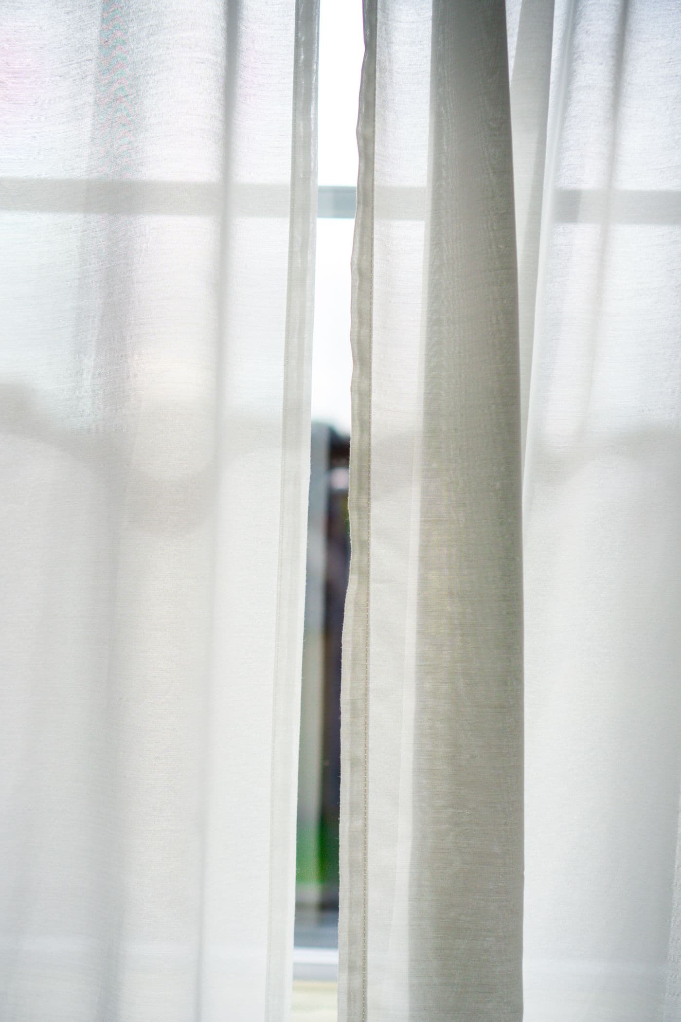 Crisp white sheer curtains at a bright window