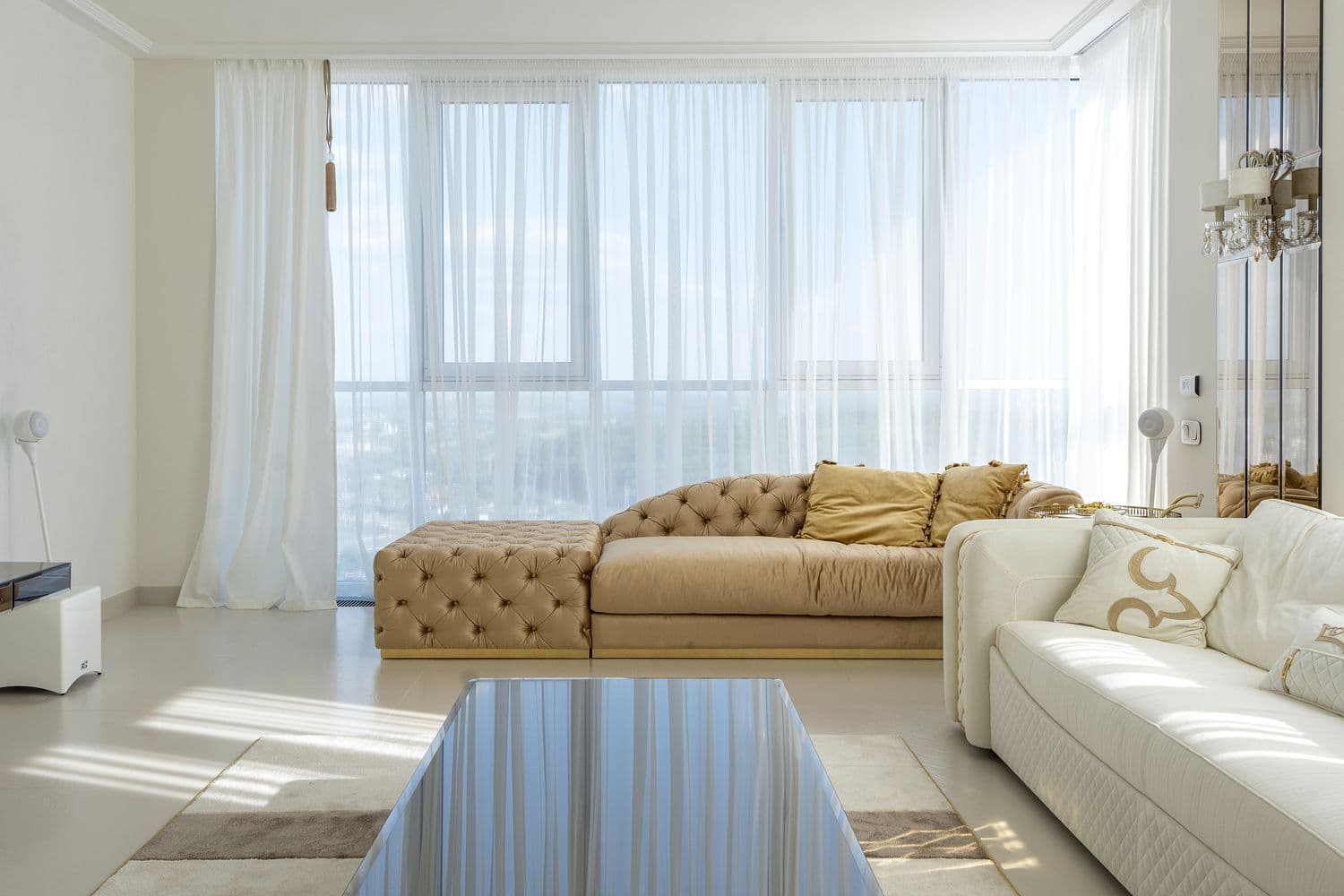 Floor-to-ceiling white sheer curtains in a bright, airy living room