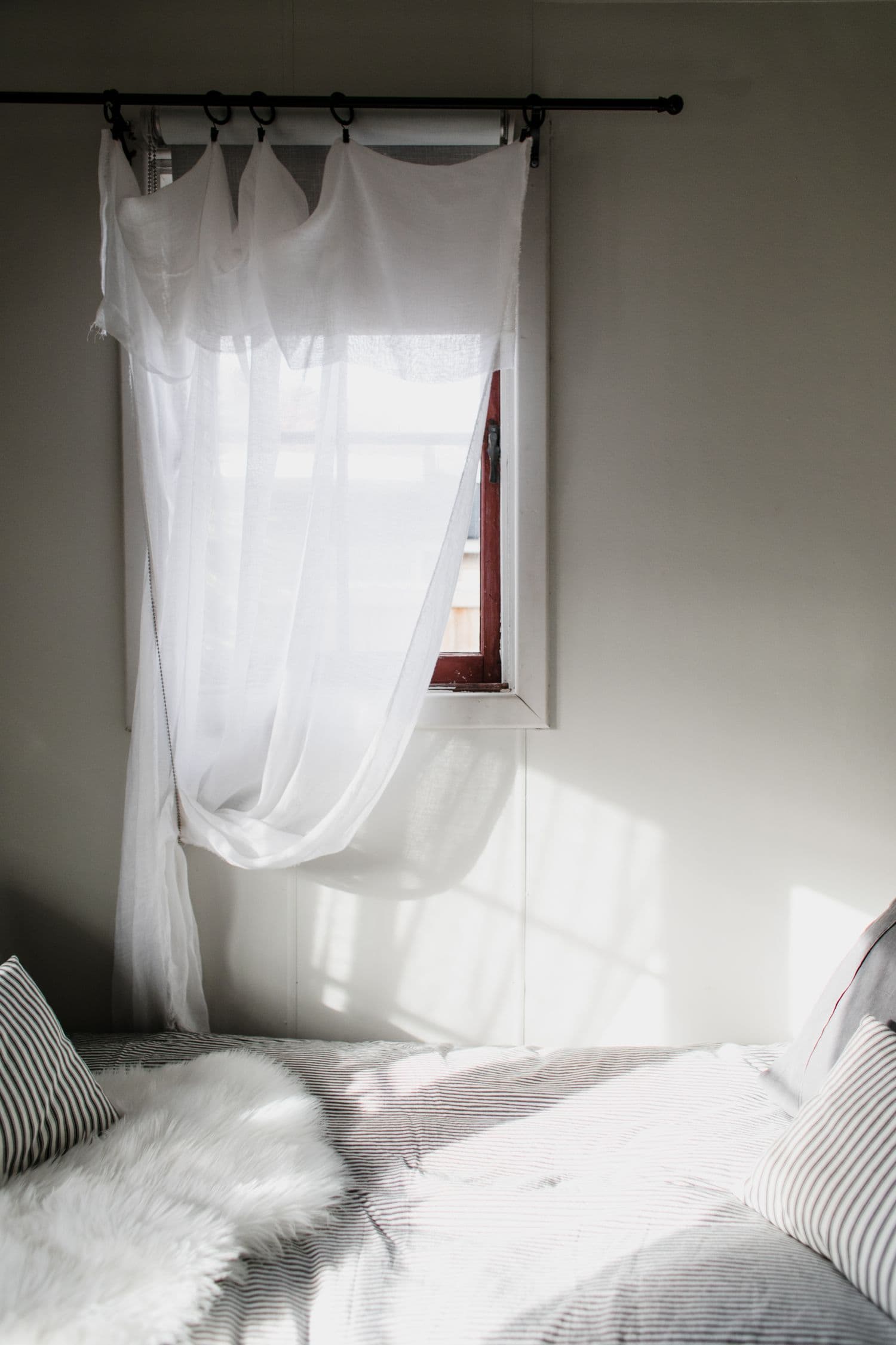 White sheer curtain in a calm Nordic bedroom