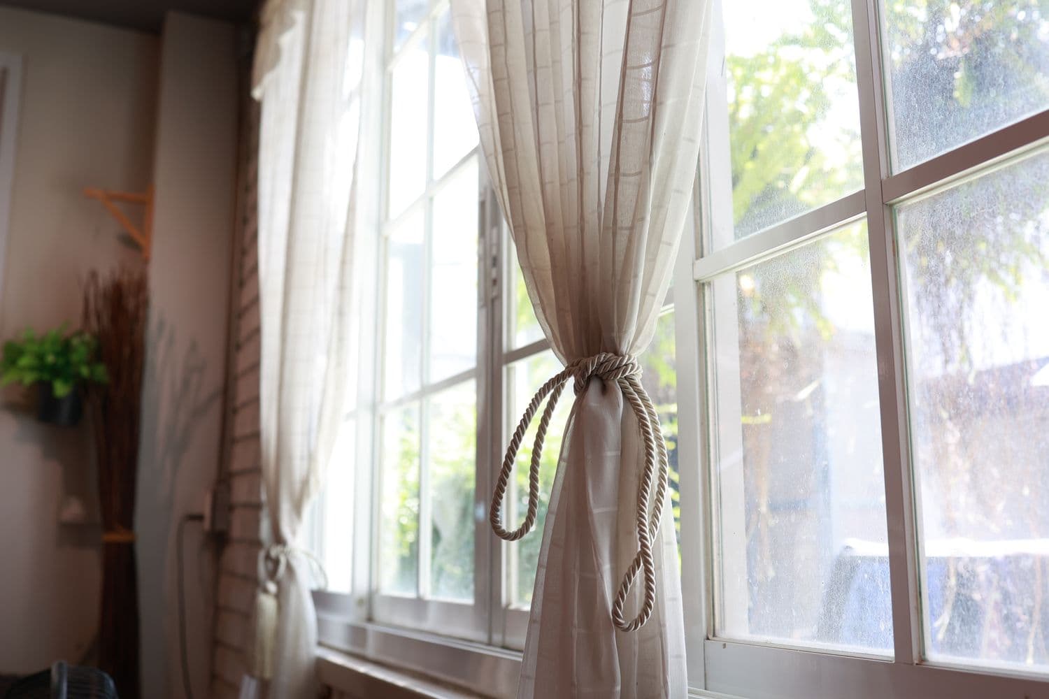 White sheer curtain tied back in soft daylight