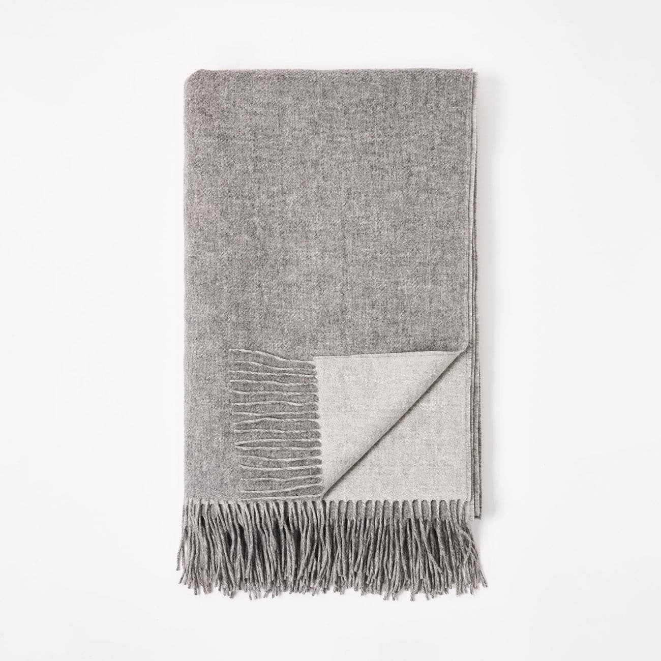 Grey fringed cashmere blanket, neatly folded