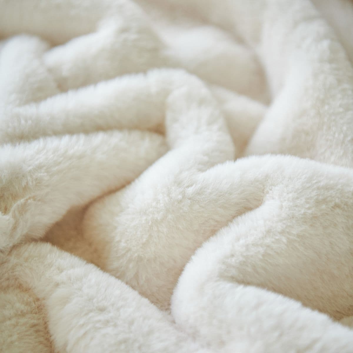 A soft ivory throw draped in plush folds