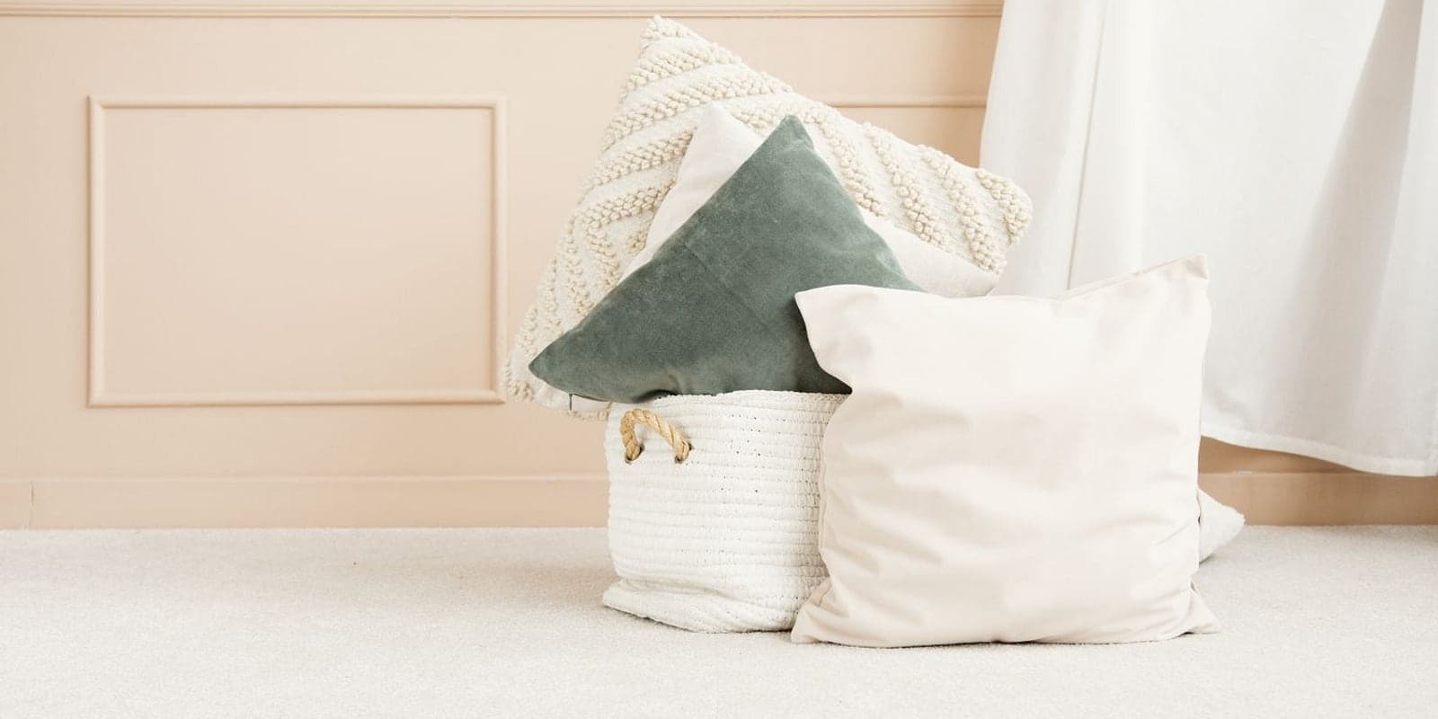 Cream and soft-sage cushions gathered in a bright corner