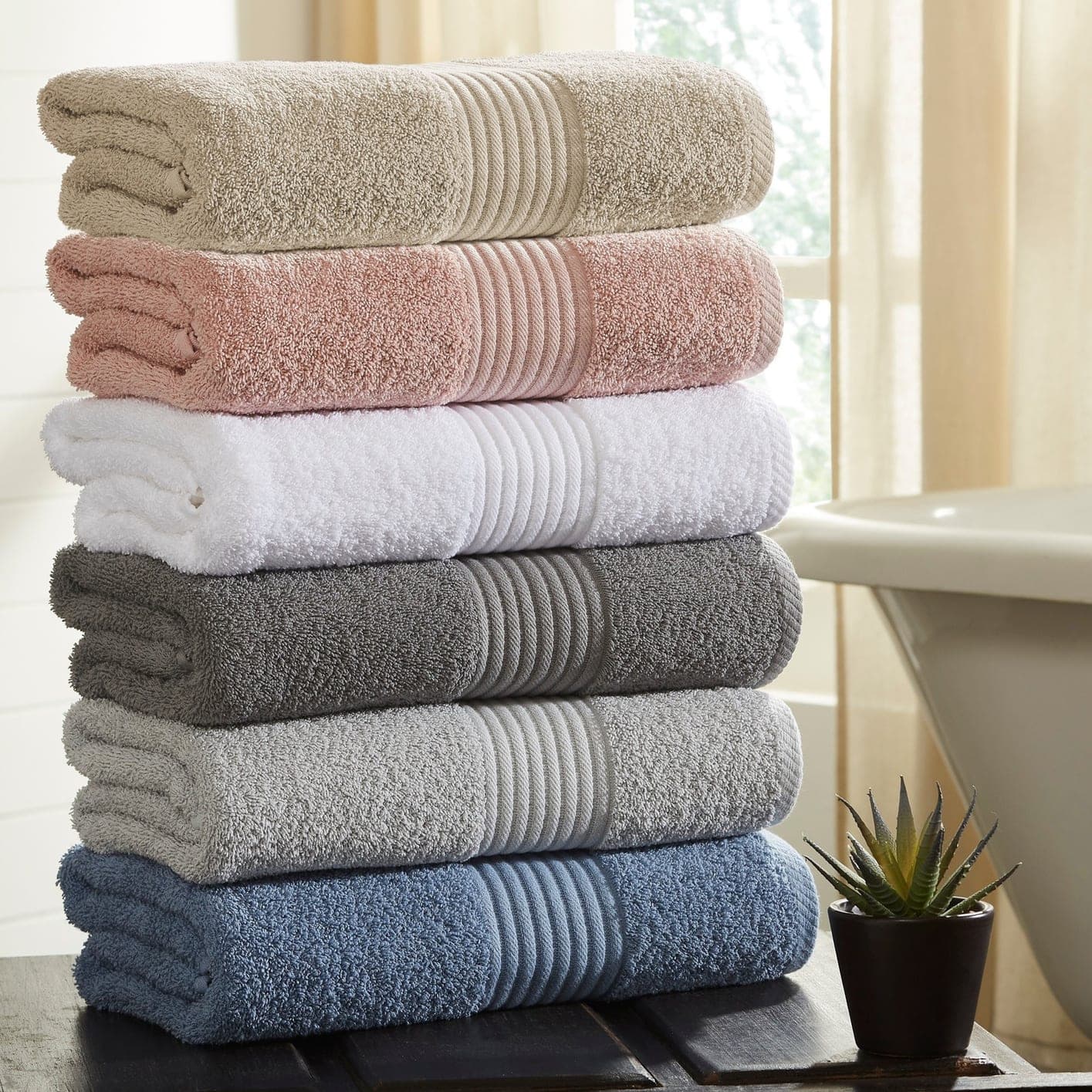 A folded stack of towels in soft neutral colours