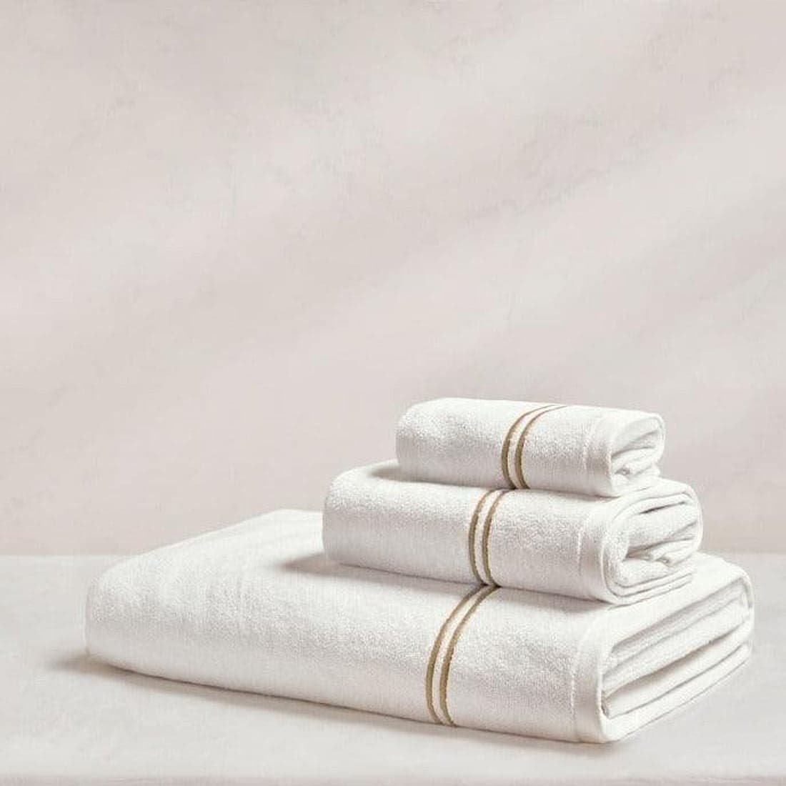 A neatly folded stack of soft white spa towels