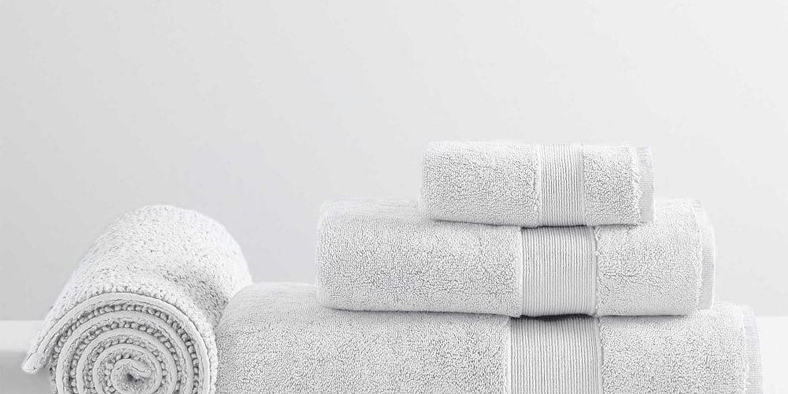 Soft white towels stacked in a bright studio