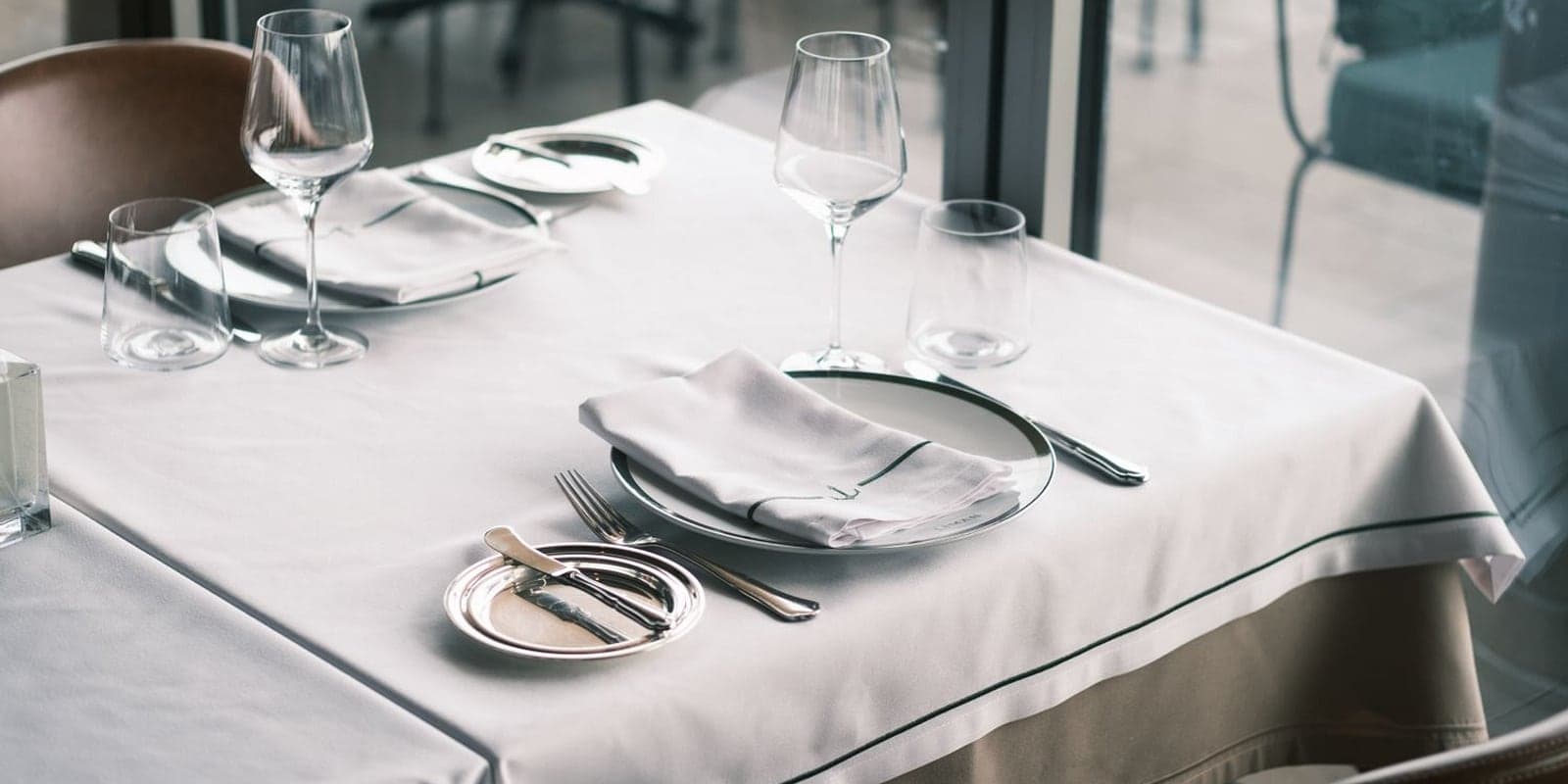 A crisp white banquet table laid with white linen