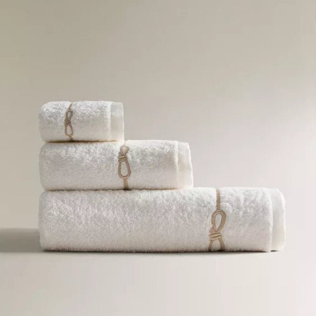 Crisp white bath towels with a subtle tan tie