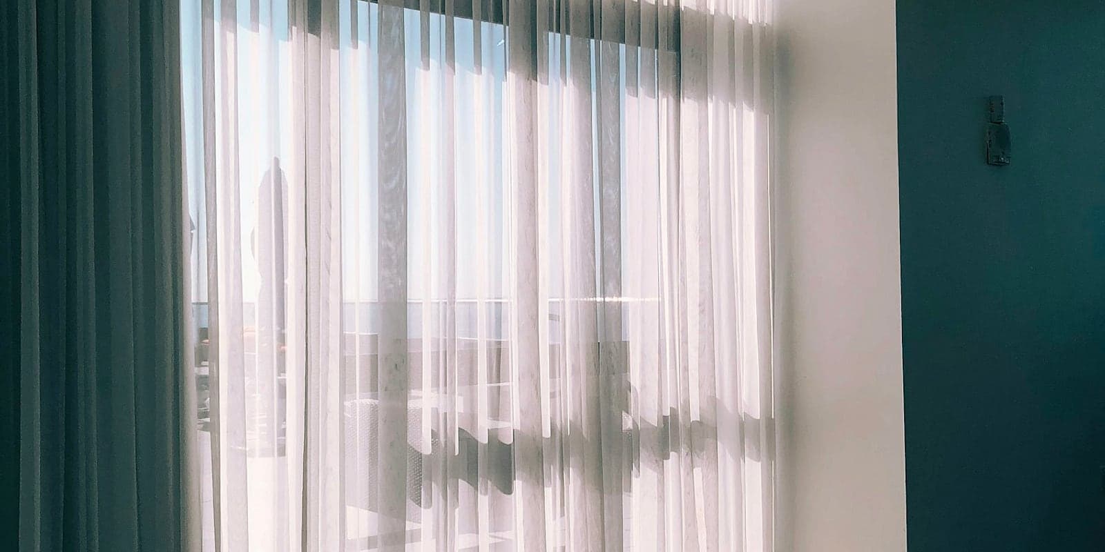 Elegant white sheers at a sunlit window