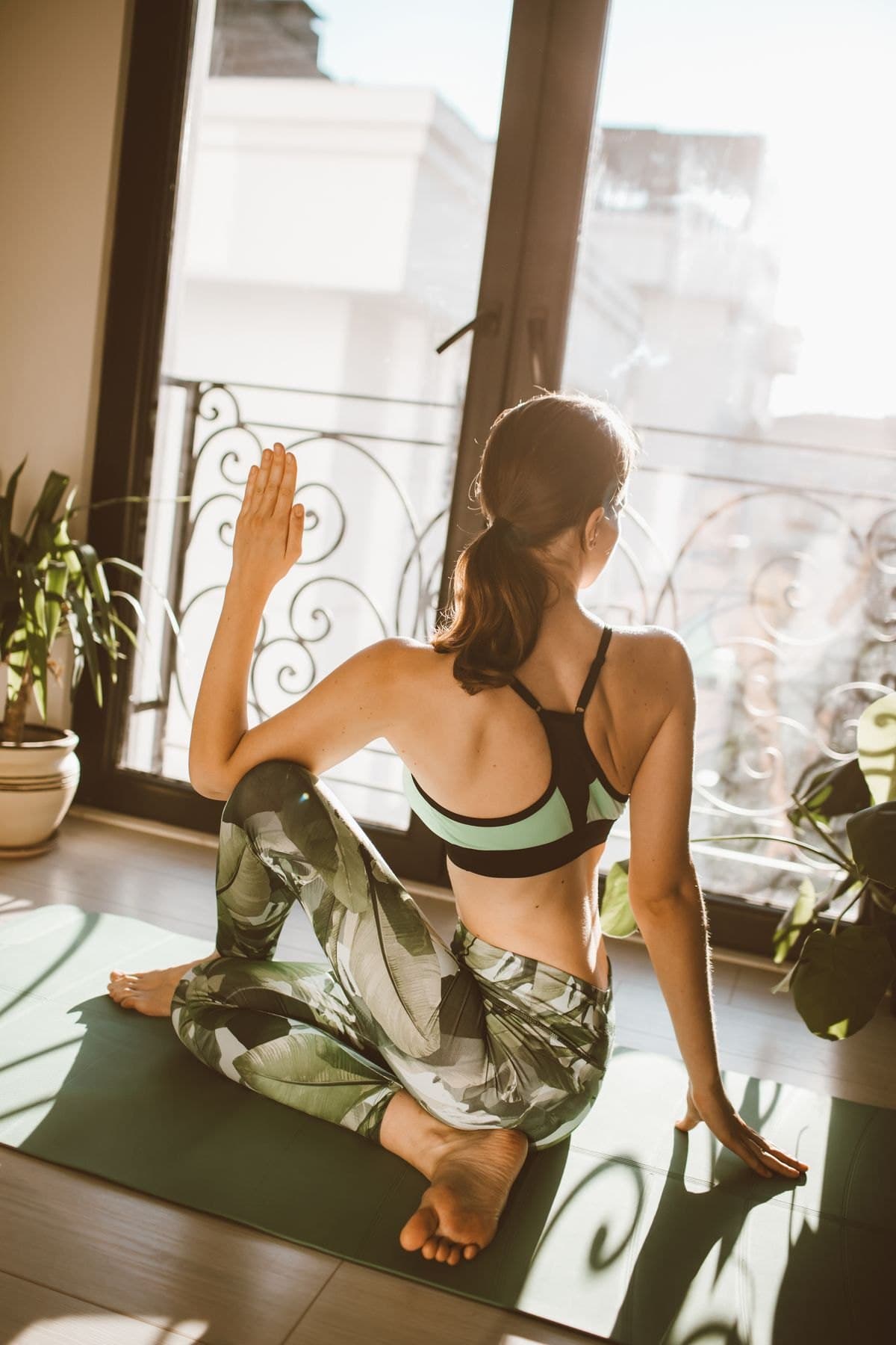Woman in a grey activewear set seated in a yoga pose