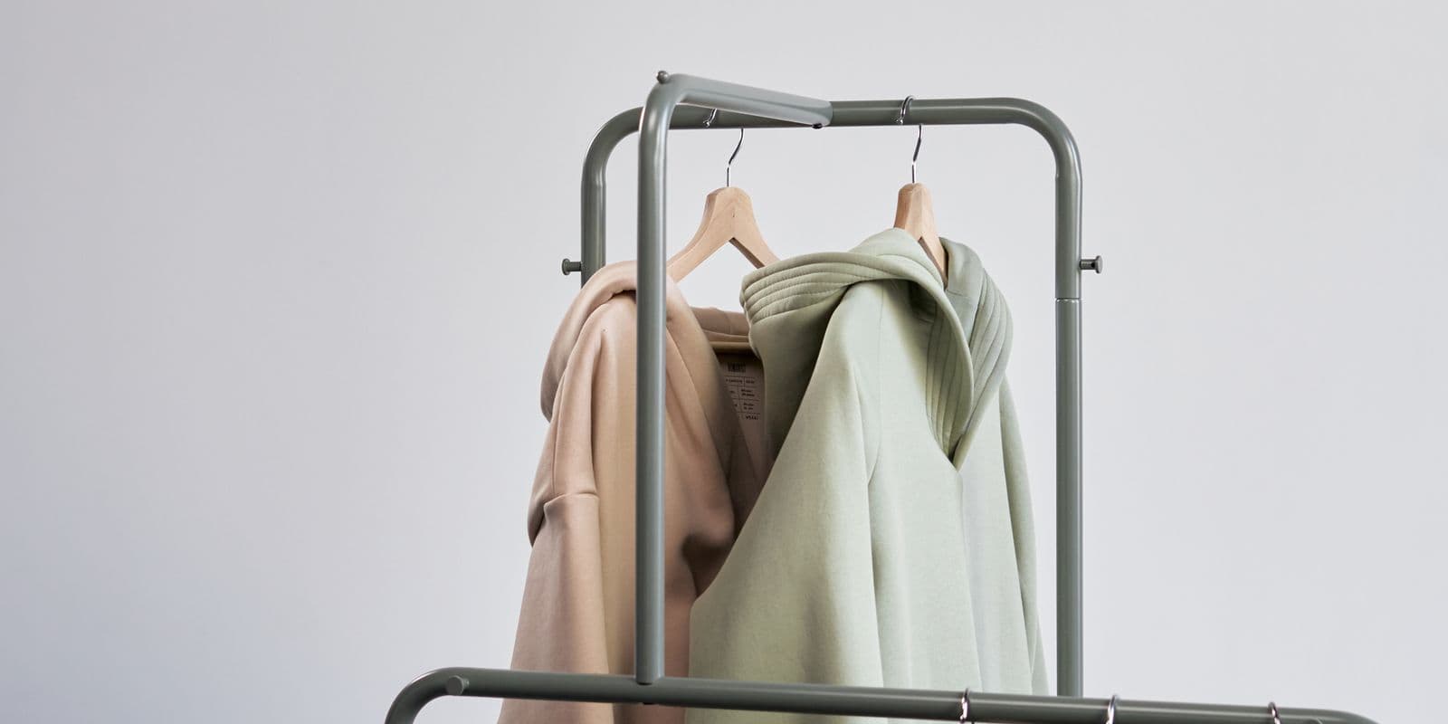 Stone and sage athletic hooded pullovers on a rail