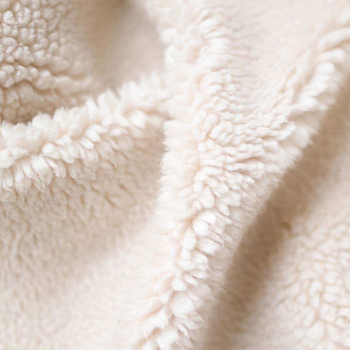 Soft cream sherpa fleece fabric in close detail