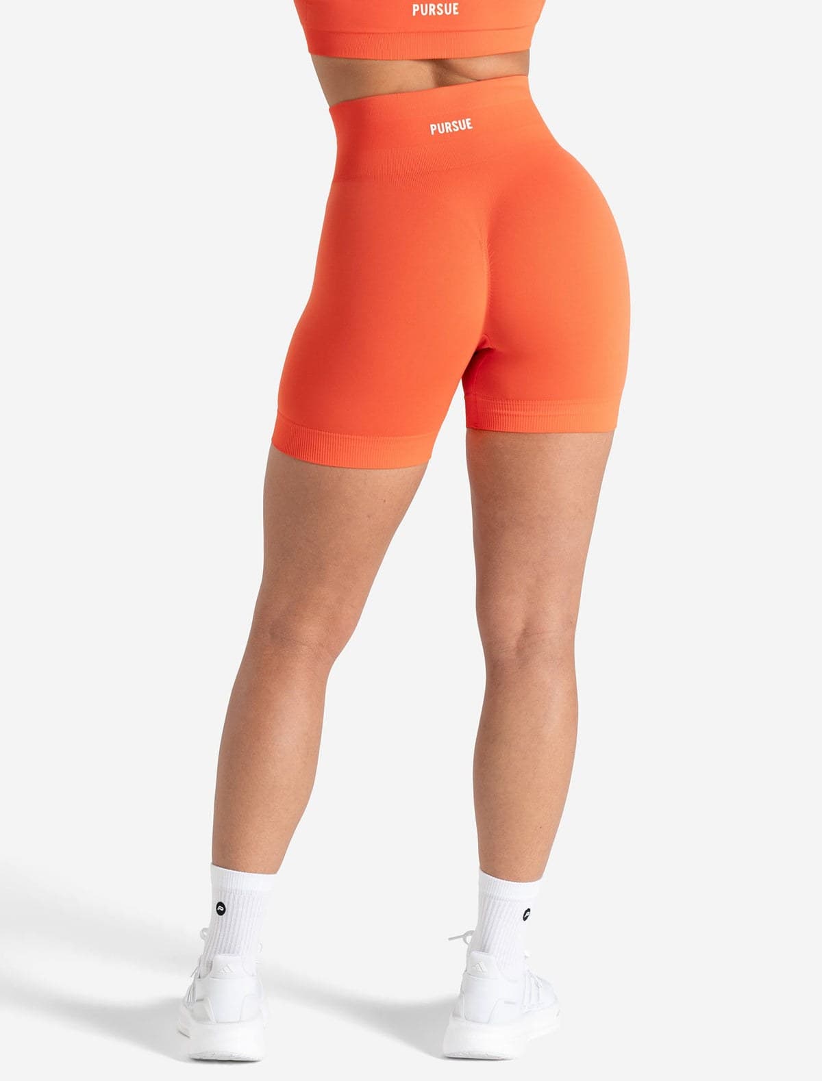 Bright coral seamless training shorts on model