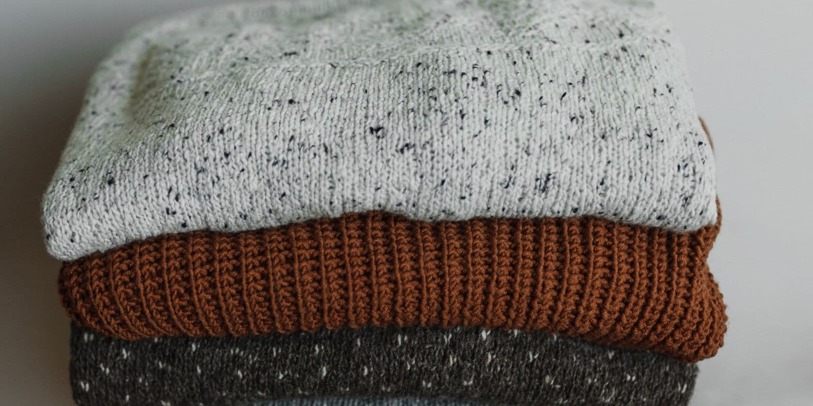 A stack of folded training tops in marl and charcoal