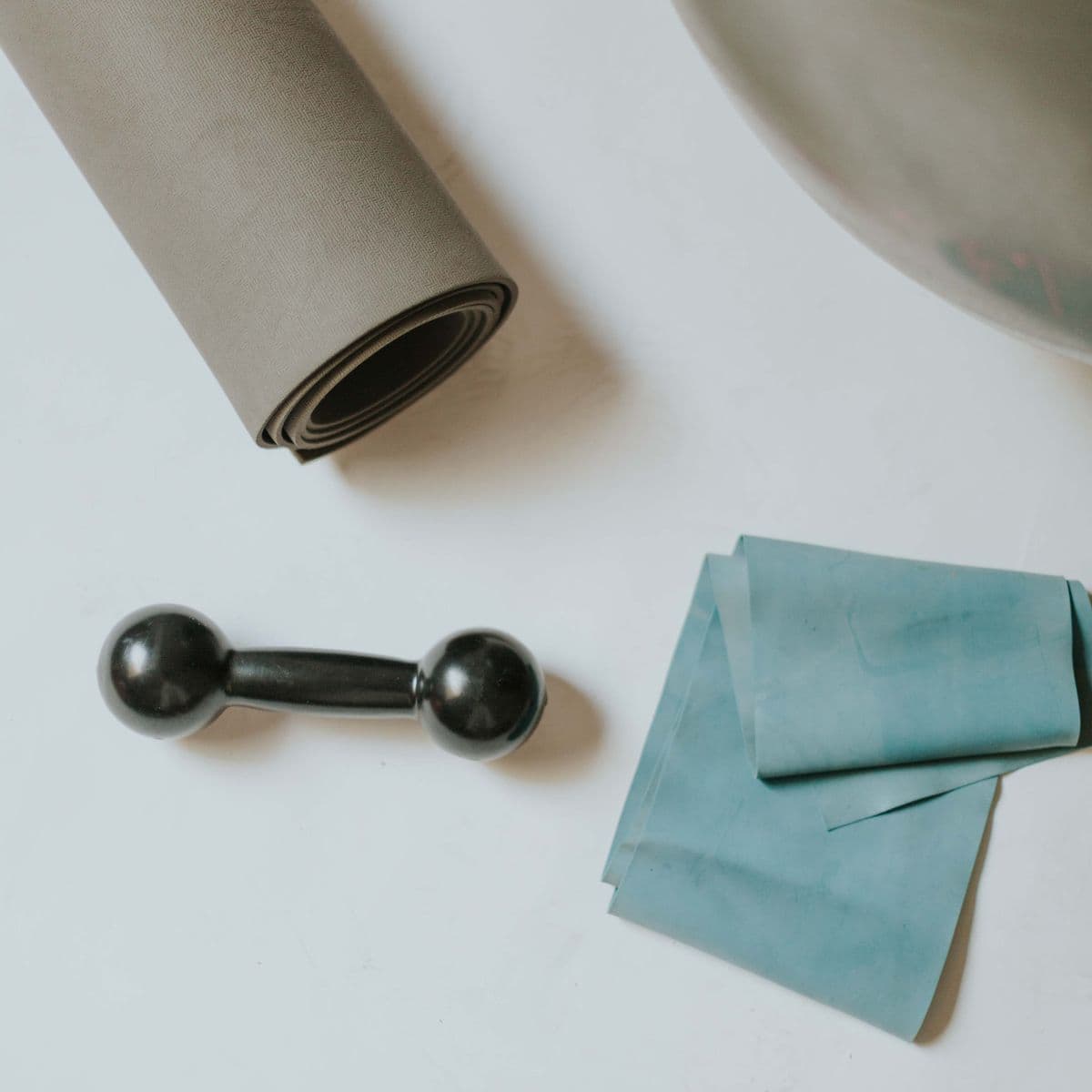 A bright flat-lay of a rolled gym mat and training kit