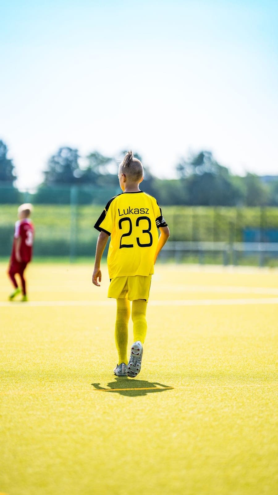 Back of a yellow team kit on the pitch