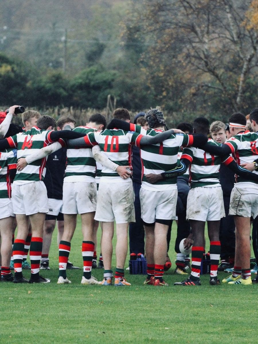 A rugby team huddle in club kit