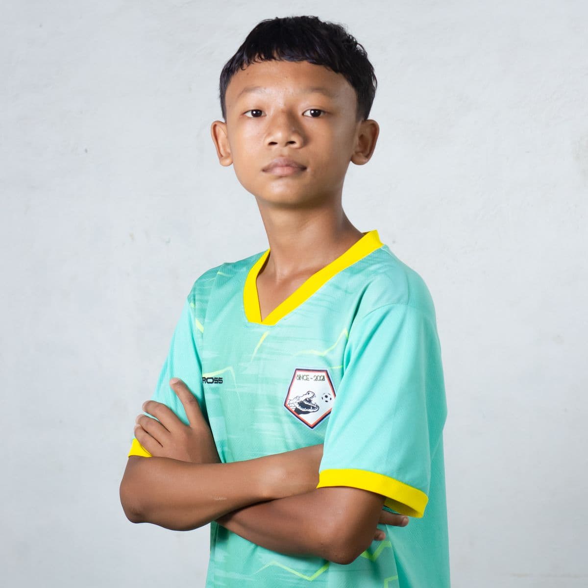 Young player in a teal-and-yellow custom football kit