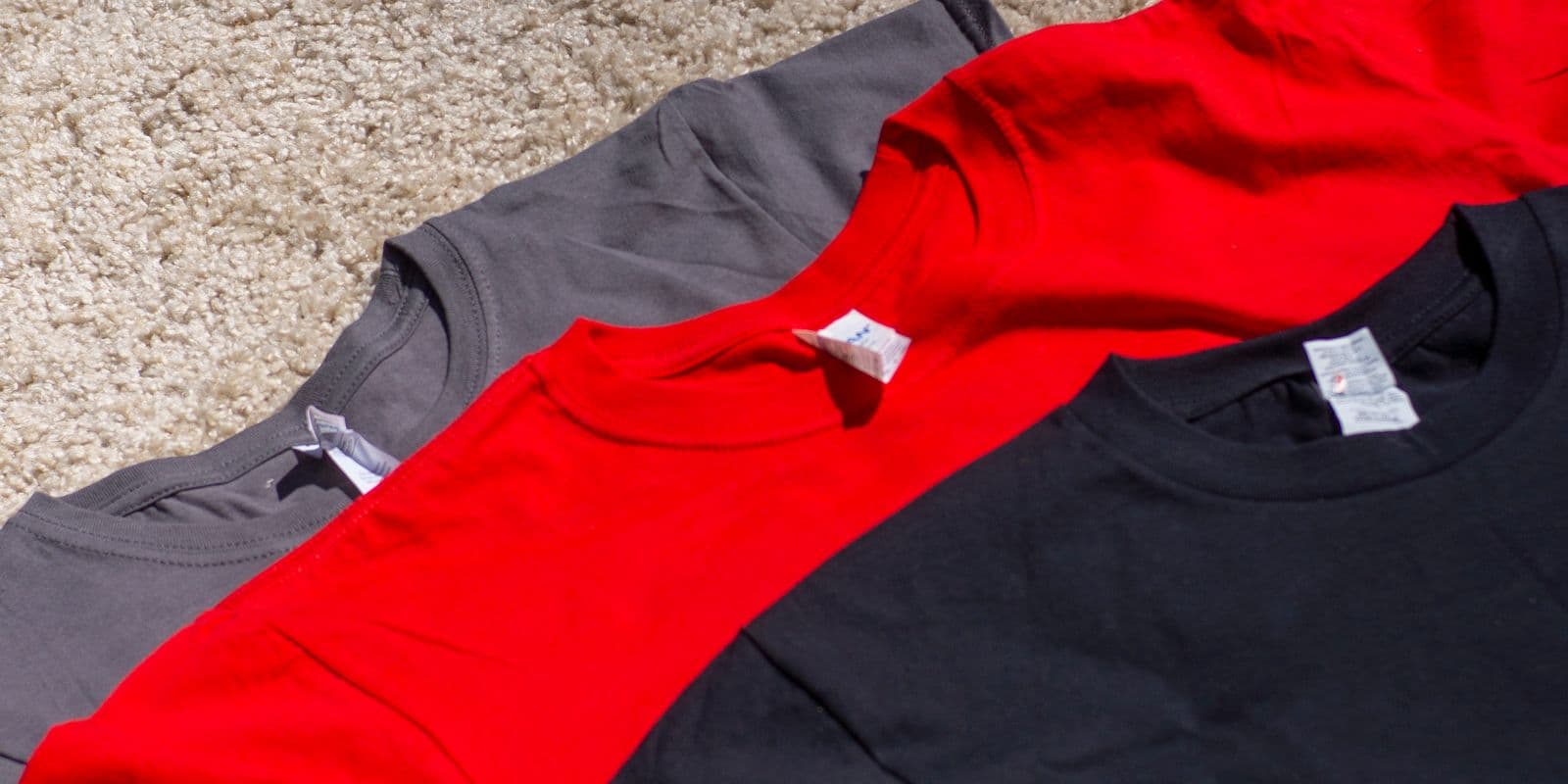 Three folded athletic tees laid flat