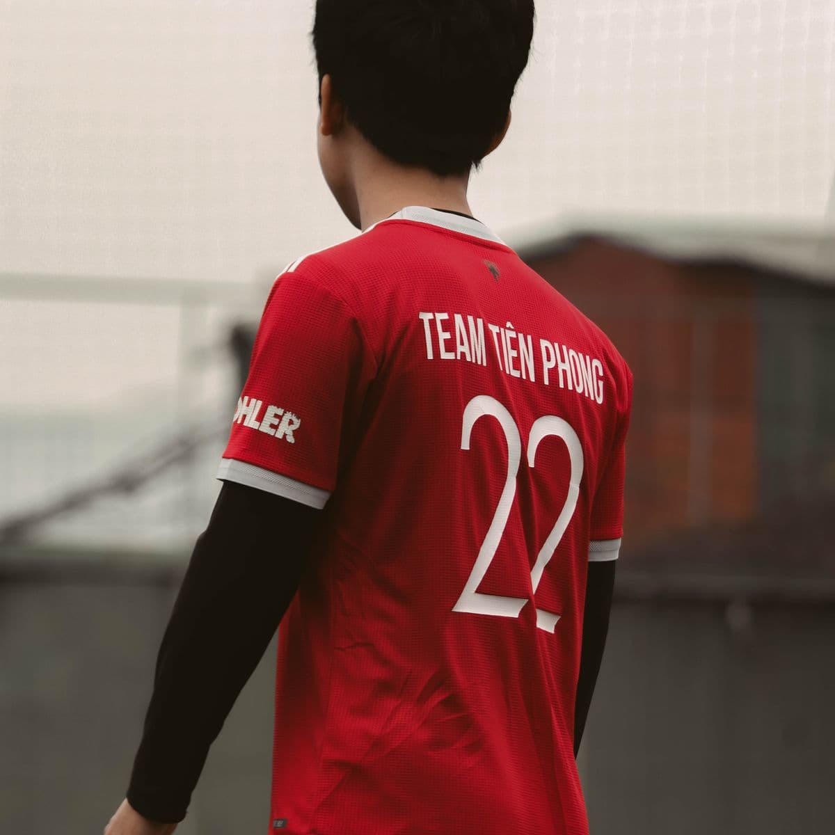 Player from behind in a red custom team shirt with printed name