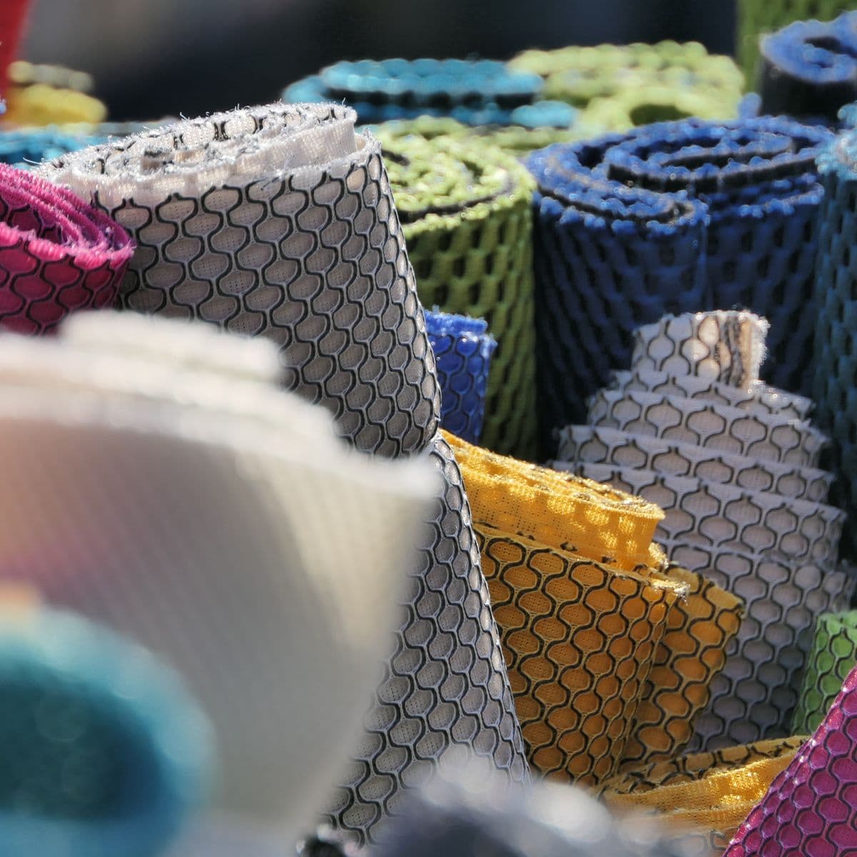 Rolls of sports jersey mesh fabric in team colours
