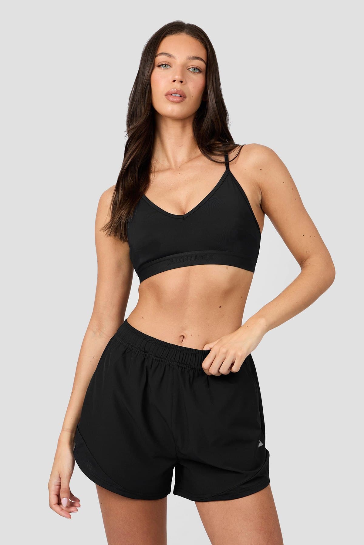 Female model in a black running bra and shorts