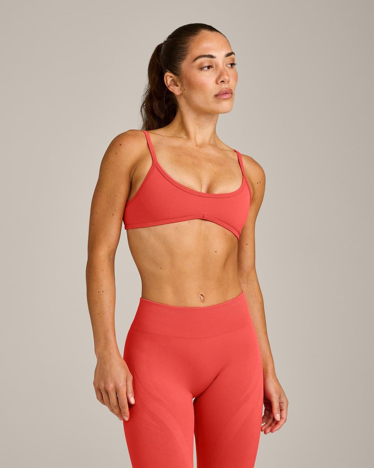 Female model in a coral red seamless set