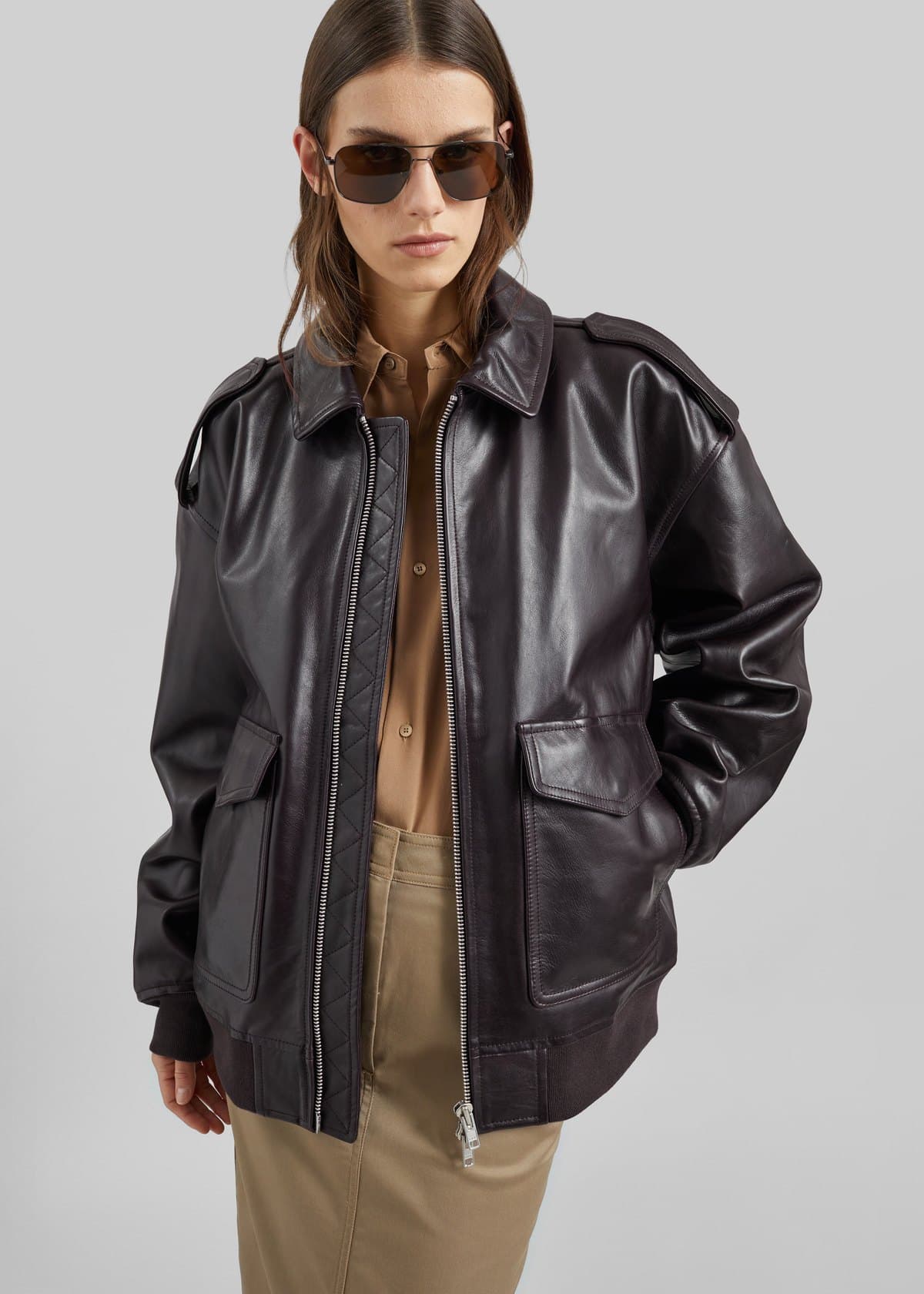 Model in a dark plum leather bomber jacket