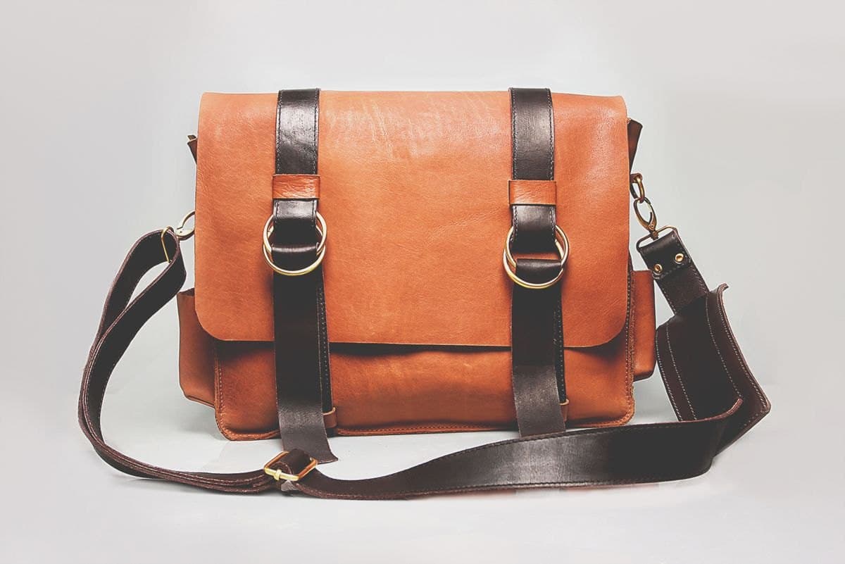 A tan leather messenger satchel with a shoulder strap