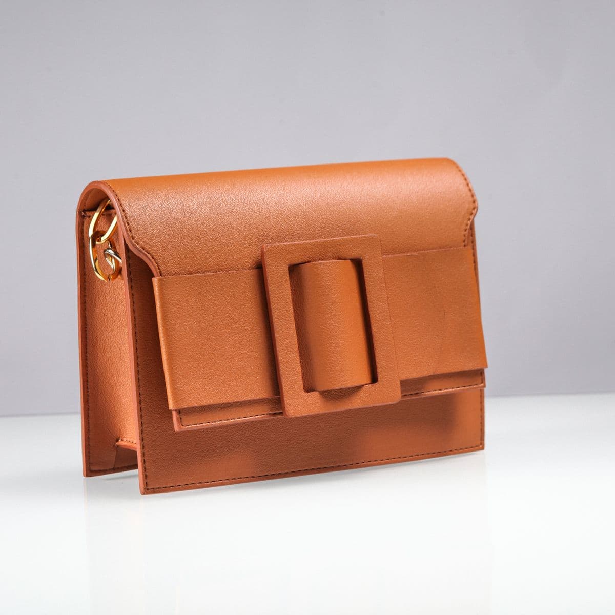 A cognac leather buckle clutch bag