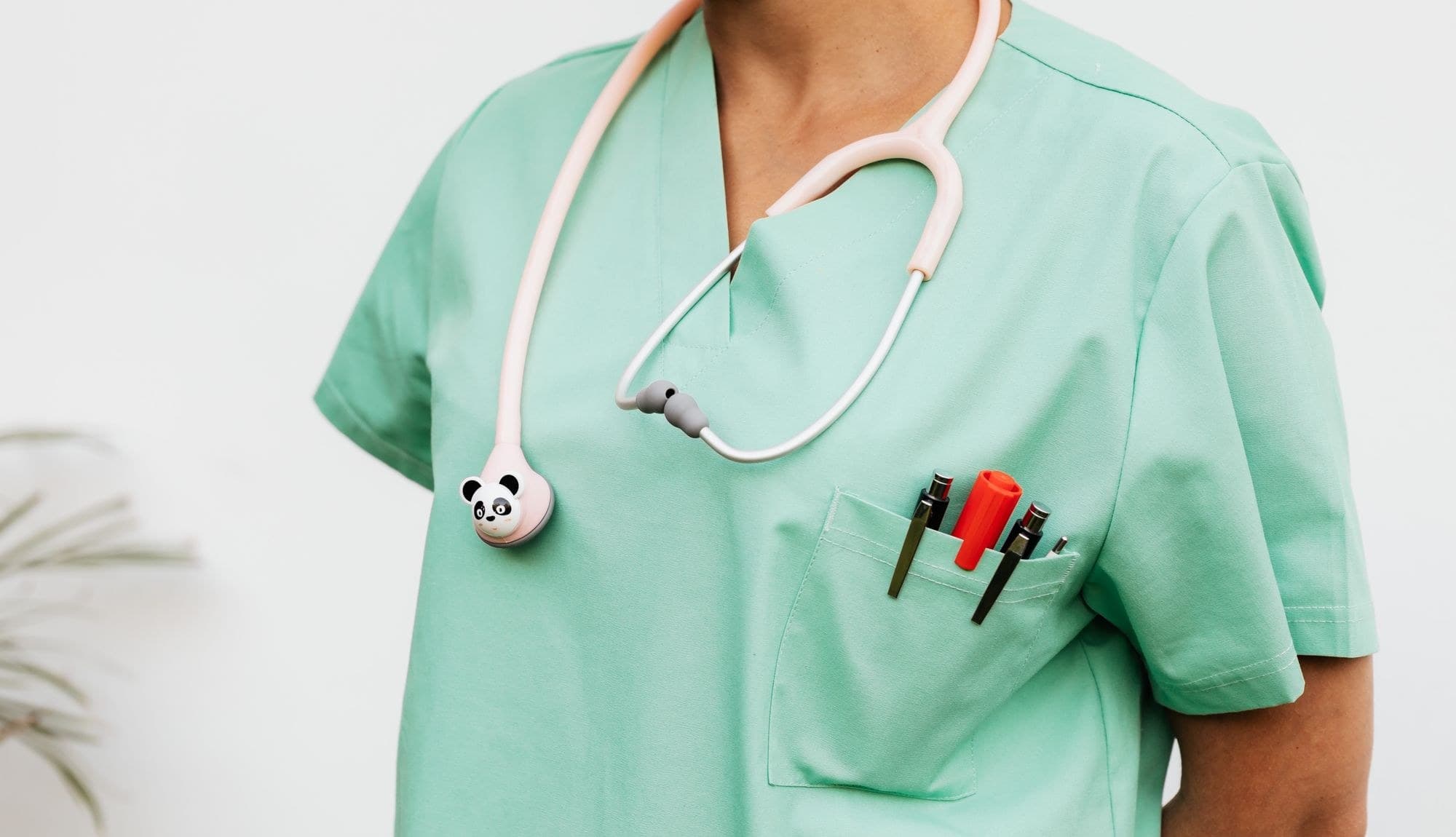 A medical professional in clean mint-green scrubs with a stethoscope