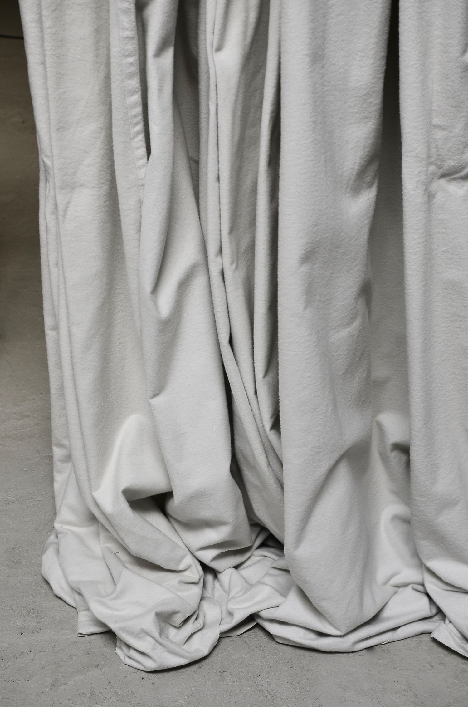 Soft white linen drapery pooling on the floor
