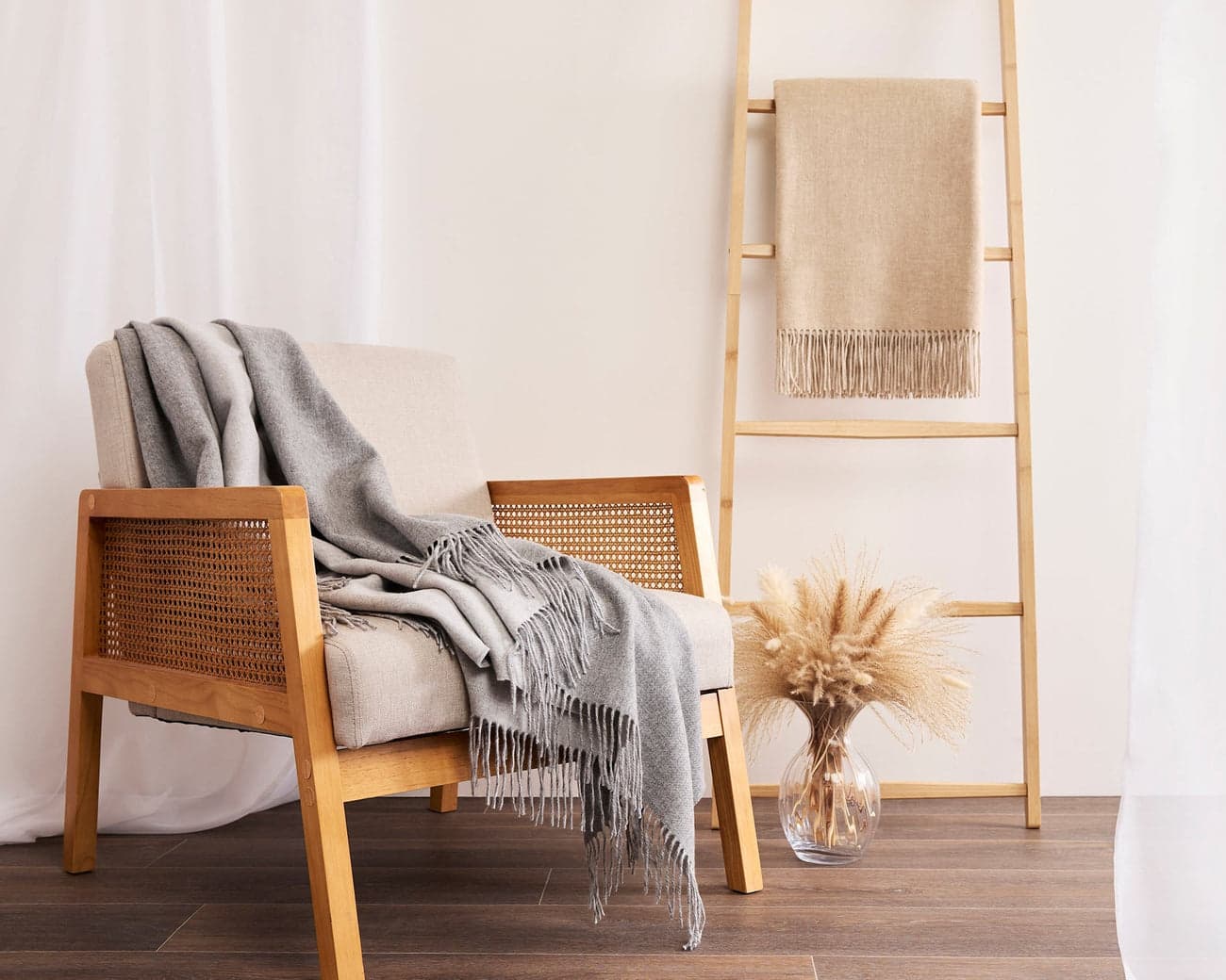 Soft grey cashmere blanket on a cane chair
