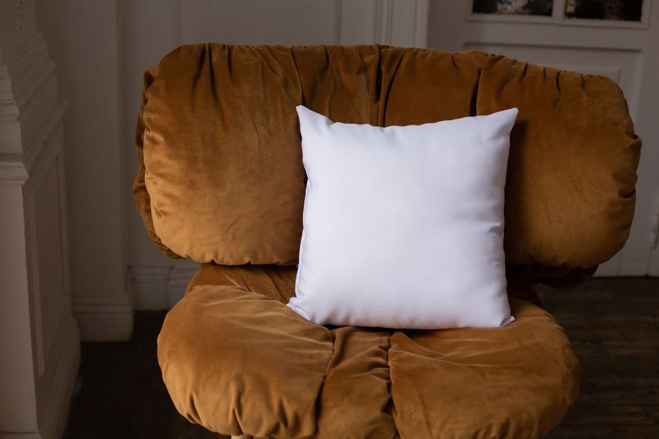 A crisp white square scatter pillow on a chair