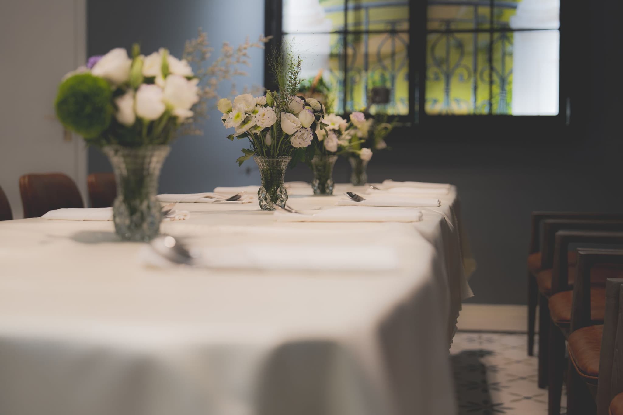 A table dressed in crisp white linen with folded napkins and soft white florals