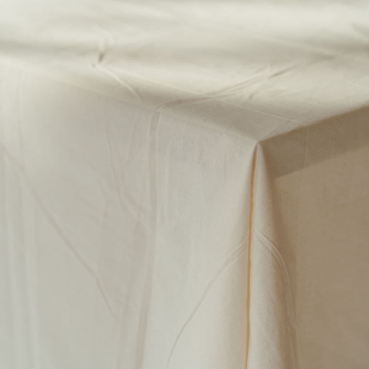 An ivory linen tablecloth draped over a table corner