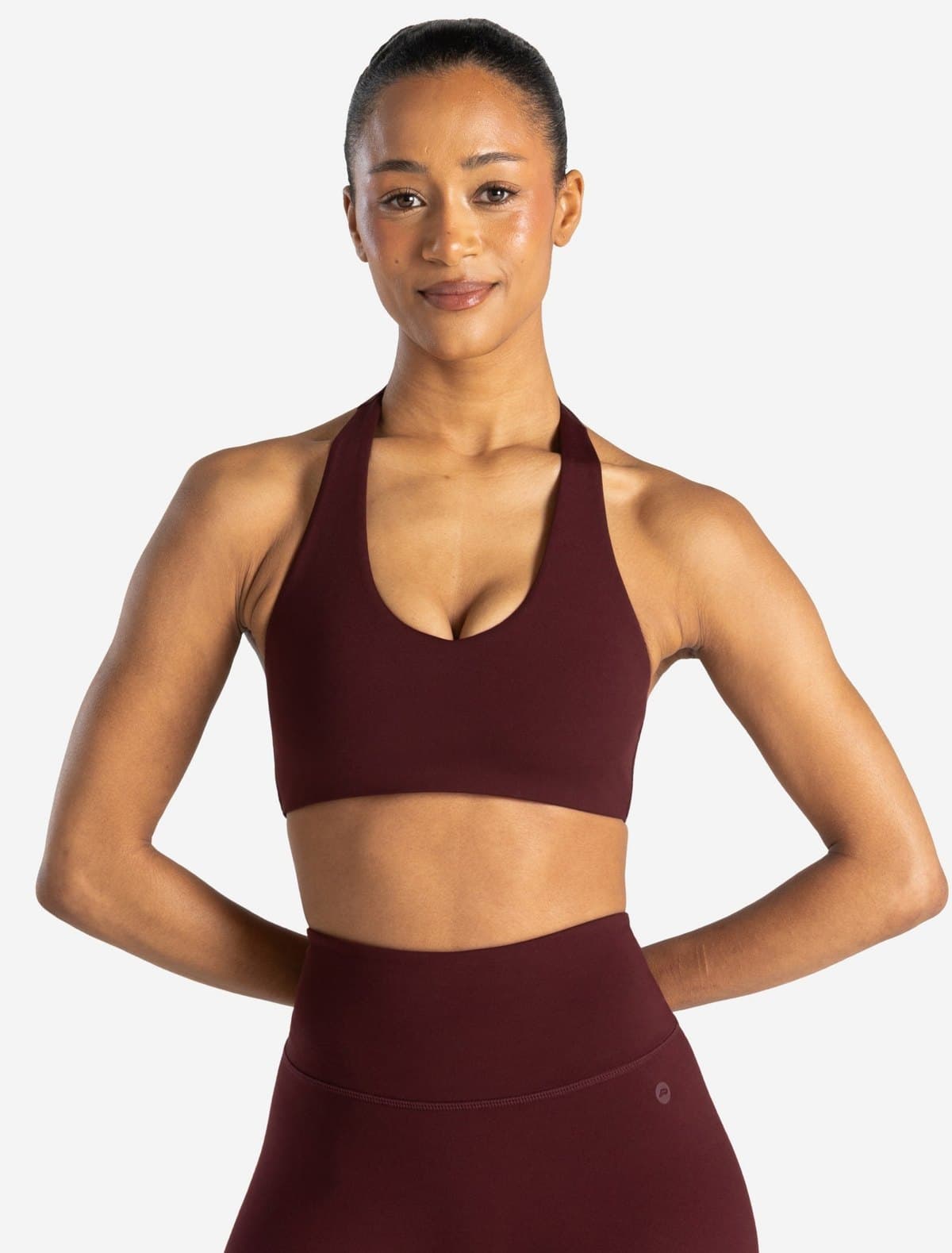 Allure halter sports bra in burgundy on a model