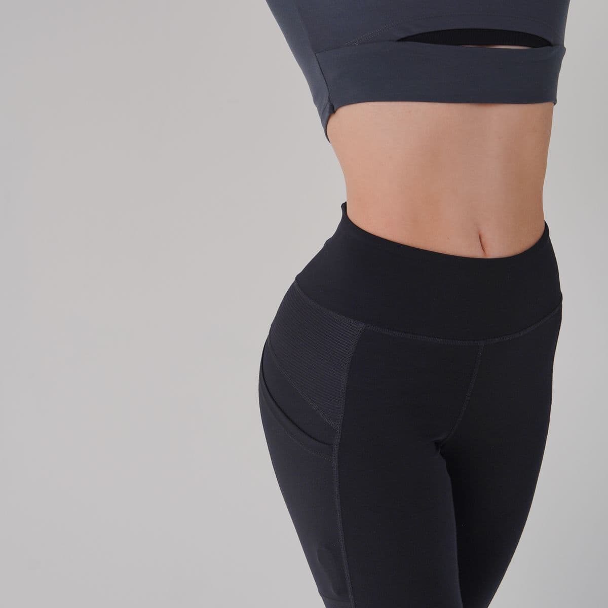 Detail of black high-waist technical leggings with bonded panels